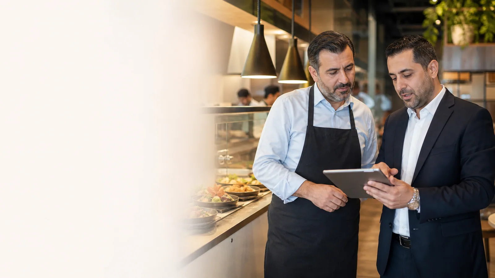 Restaurant owner and franchise manager reviewing branch performance